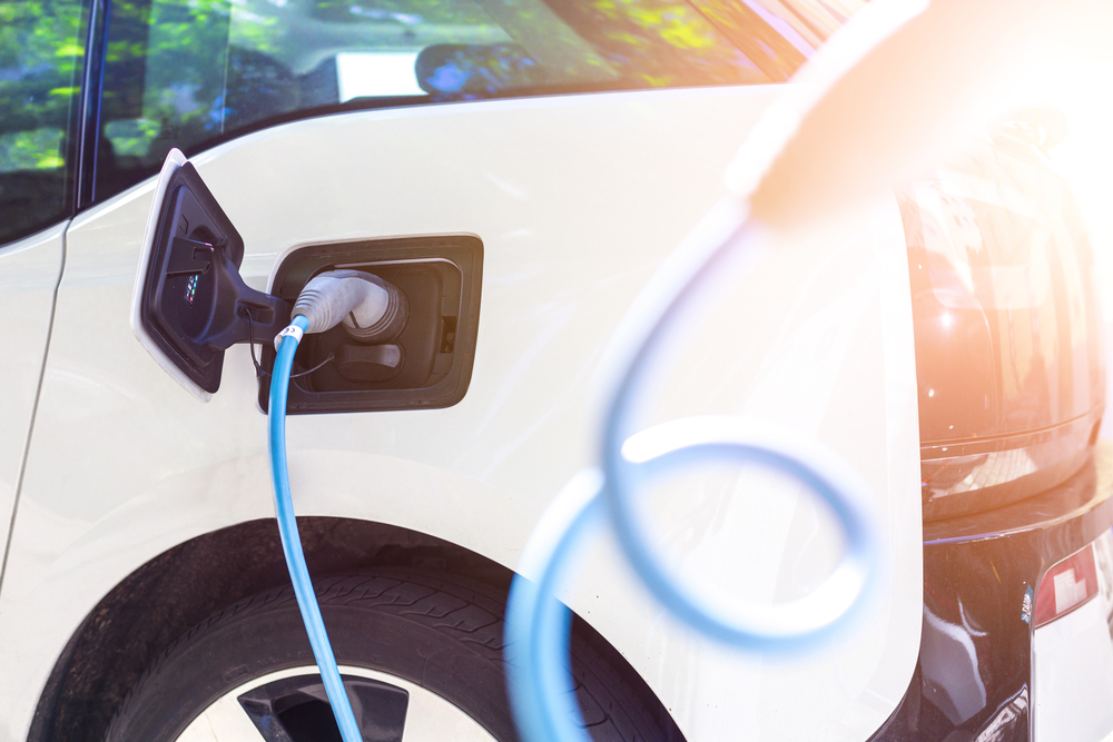 An electric car is recharging at a charging station