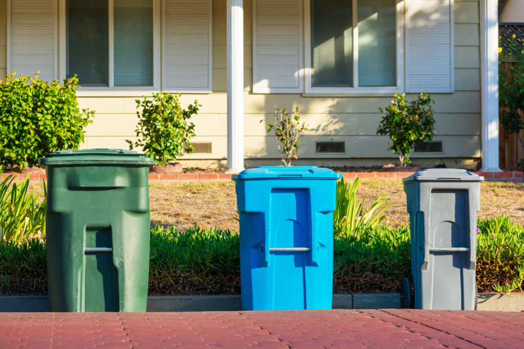 Compost, recycling and garbage carts set outside of the home on the curb for residential garbage and recycling pickup.